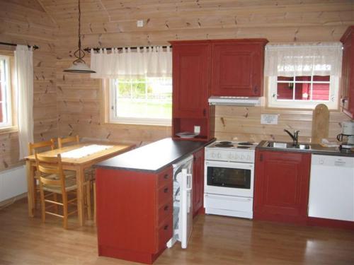 a kitchen with a stove top oven, stove top microwave and refrigerator at Røldal Hyttegrend & Camping in Røldal