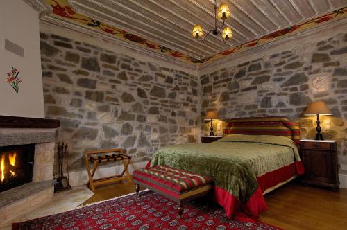 a bedroom with a bed and a stone wall at Emotions Country Resort in Voútiron