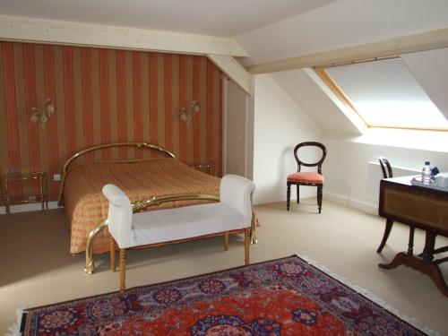 a bedroom with a bed and a chair and a table at il giardino F Heudier ,E Decourcy ,Tessy sur vire Manche in Tessy-sur-Vire