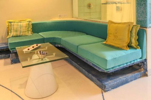 
a green couch sitting on top of a table at Waterstones Hotel in Mumbai
