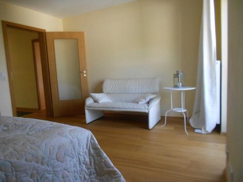 a bedroom with a bed and a chair and a table at Quartier 1 in Freiburg im Breisgau