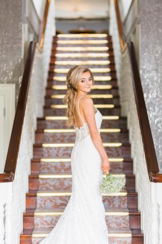 a woman in a wedding dress walking down the stairs at Mellon Country Inn Hotel in Omagh