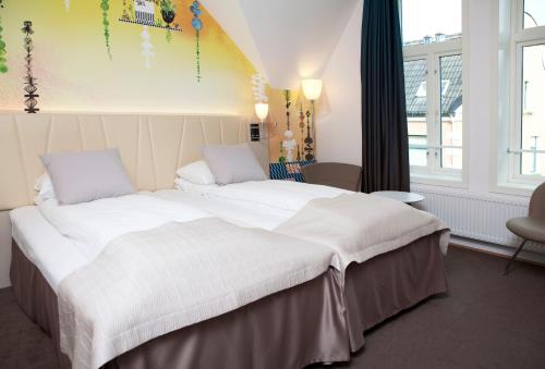 a bedroom with a large bed with white sheets at Quality Hotel Waterfront in Ålesund