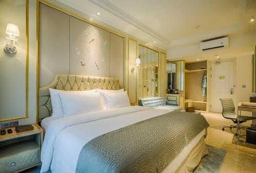 a hotel room with a large bed and a desk at Art Deco Luxury Hotel & Residence in Bandung