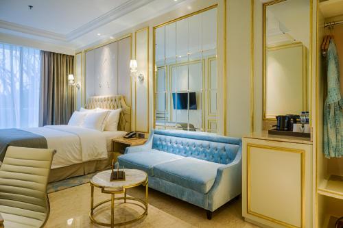 a hotel room with a bed and a couch at Art Deco Luxury Hotel & Residence in Bandung