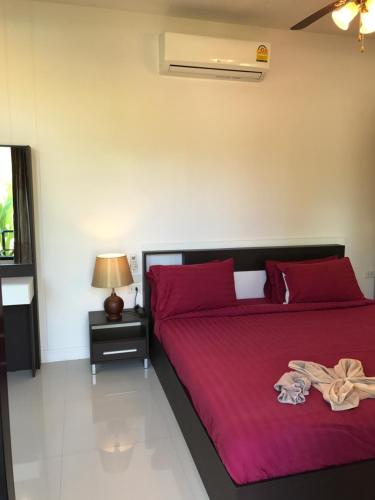 a bedroom with a bed with red pillows at Saree Lagoon Villa Koh Samui in Lipa Noi