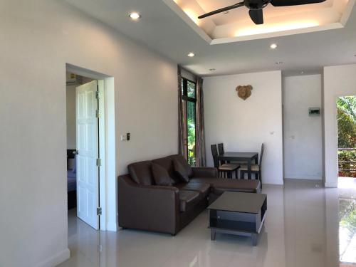 a living room with a couch and a table at Saree Lagoon Villa Koh Samui in Lipa Noi