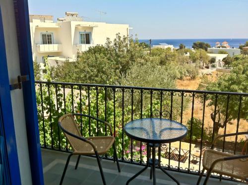 a table and chairs on a balcony with a view of the ocean at Castellania Hotel Apartments in Livadia