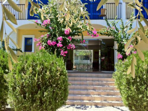 a house with pink flowers in front of it at Castellania Hotel Apartments in Livadia