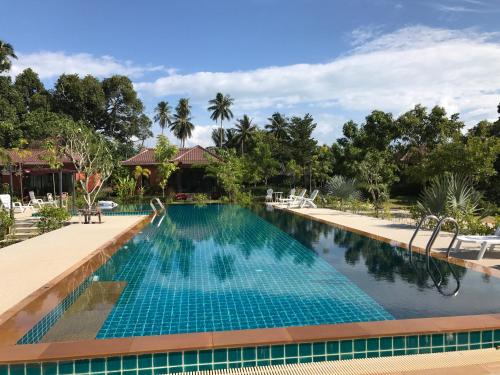 a pool at a resort with blue water at Saree Lagoon Villa Koh Samui in Lipa Noi