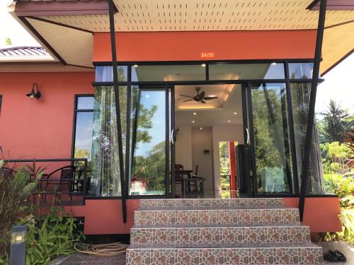 a house with glass doors and stairs in front at Saree Lagoon Villa Koh Samui in Lipa Noi