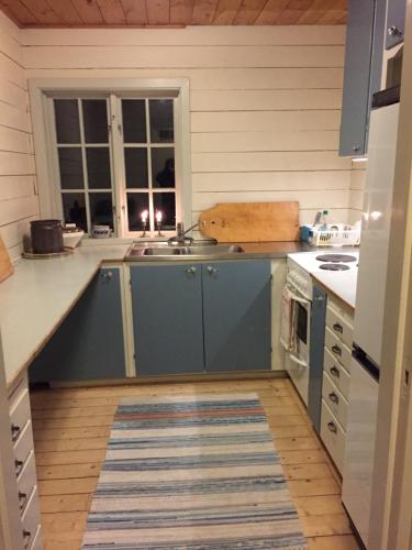 a kitchen with a sink and a stove at Marjas stuga in Norråker
