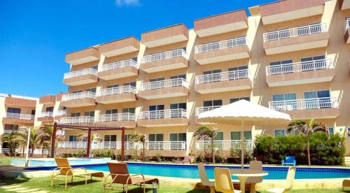 un gran edificio de apartamentos con sillas y piscina en Vila Dunas, en Aquiraz