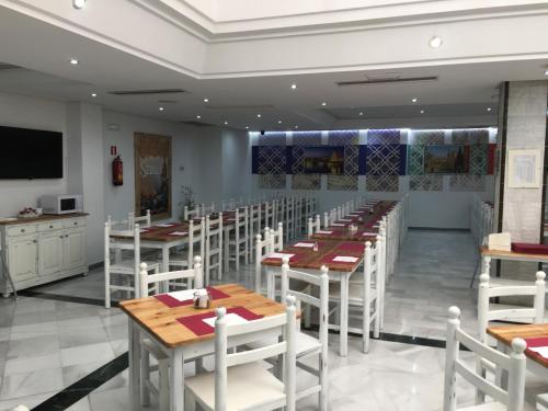 a dining room with wooden tables and white chairs at Hotel San Pablo Sevilla in Seville