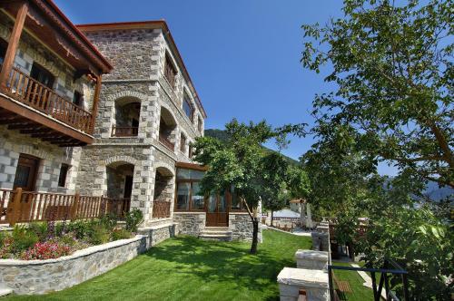 a large stone house with a yard in front of it at Emotions Country Resort in Voútiron