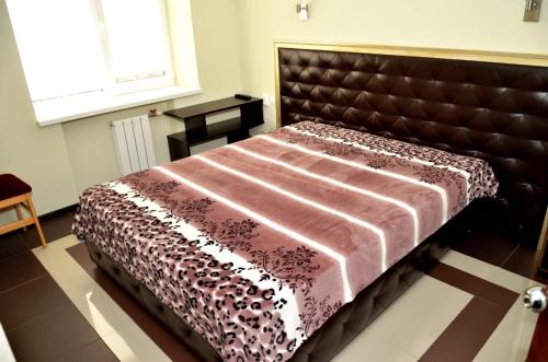 ジェレスノヴォツクにあるApartments RING Zheleznovodskのベッドルーム1室(ブラウンのヘッドボード付きのベッド1台付)