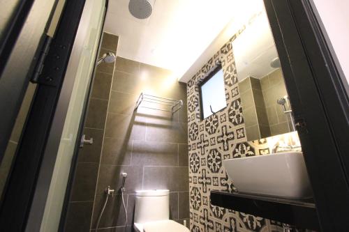 a bathroom with a sink and a toilet and a mirror at Vista Horizon Melaka in Melaka