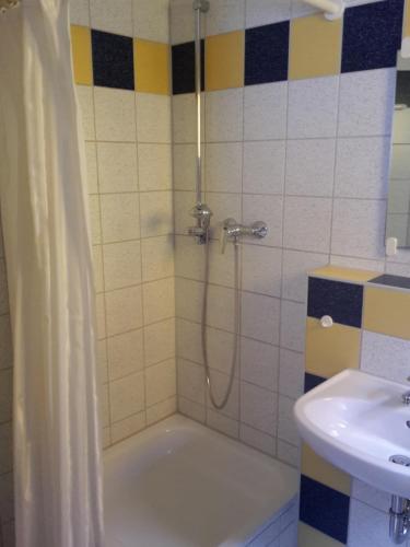 a bathroom with a shower and a tub and a sink at Motel Am Highway in Althengstett
