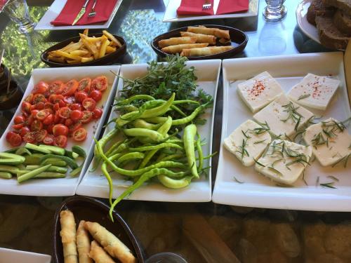 KayakoyにあるPyramid Boutique Hotelのさまざまな種類の食べ物が載ったトレイが置かれたテーブル