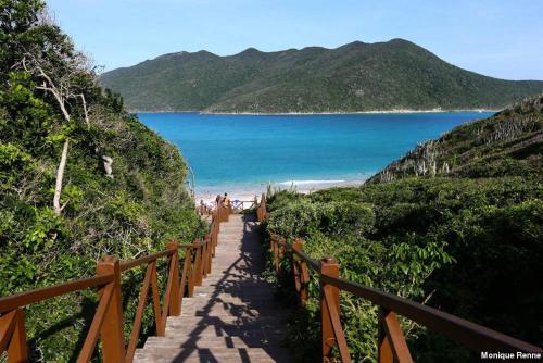 a stairway leading down to a beach with the ocean at Pousada Palmares in Cabo Frio