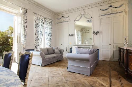 a living room with two chairs and a mirror at Chambres d'hotes de Pouzelande in Notre-Dame-de-Sanilhac