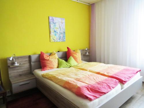 um quarto com uma cama com almofadas coloridas em Hamax em Dresden