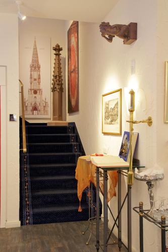 a room with a staircase with a table and a stair case at Park Hotel Post in Freiburg im Breisgau