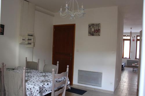 a dining room with a table and a chandelier at Apparts St Sépulcre in Saint-Omer