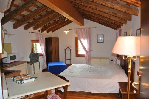 ein Schlafzimmer mit einem Bett und einem Tisch mit einer Lampe in der Unterkunft Agriturismo Terra di Zosagna in Breda di Piave