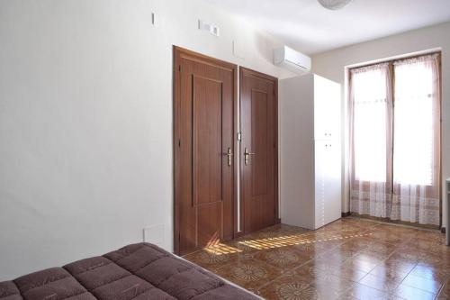 - une chambre avec un lit et une porte en bois dans l'établissement La Tana del Lupo, à San Giovanni Gemini
