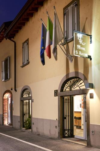 a building with flags on the side of it at San Rocco Hotel in Scanzorosciate