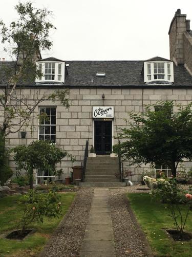 a white brick building with a sign that reads crockery at Crown Guest House in Aberdeen