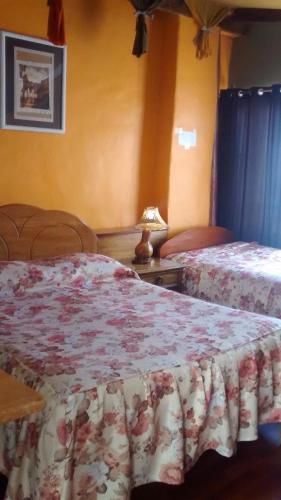 a bedroom with two beds and a table with a lamp at Casa De Mama Cusco - The Treehouse in Cusco