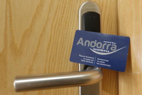 a sign is attached to a metal door handle at Hotel-Apartamentos Andorra in Playa de las Americas