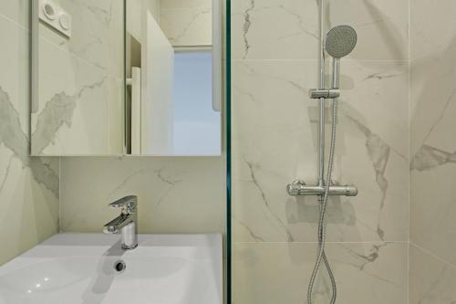 une salle de bain avec une douche avec un lavabo et une douche dans l'établissement Pick a Flat's Apartment in Montmartre - Rue des Martyrs studio, à Paris