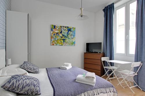 a bedroom with a bed and a table and a window at Pick a Flat's Apartment in Montmartre - Rue des Martyrs studio in Paris