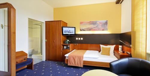 a hotel room with a bed and a television at Park Hotel Post in Freiburg im Breisgau