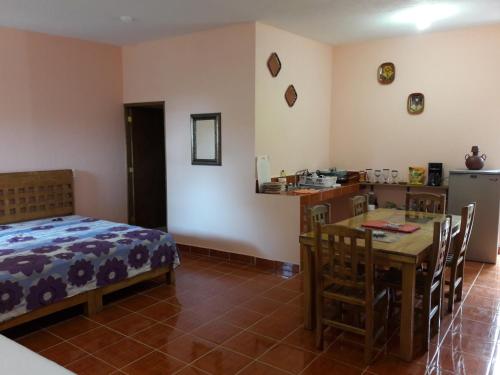 a bedroom with a table and a bed and a kitchen at Hotel Villas Monteli Suites Cuernavaca in Cuernavaca