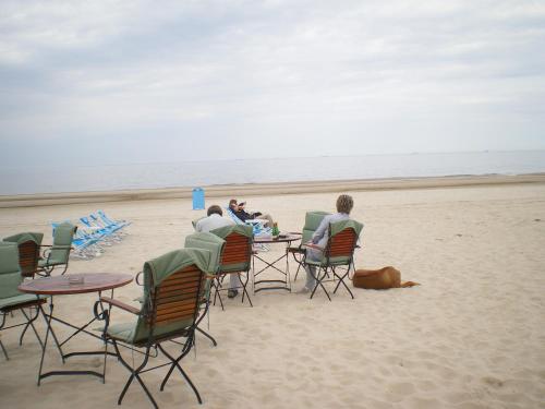 a group of people sitting at tables on the beach at Strandburg, das smarte Penthouse in ÜckeRitz mit PKW Stellplatz! in Ueckeritz
