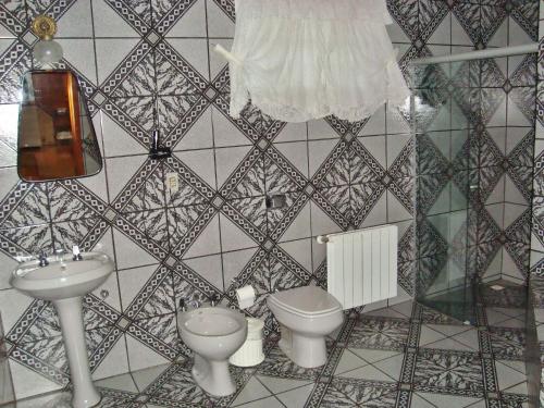 a bathroom with two toilets and a sink at Motel Monza (Adults Only) in Farroupilha