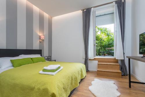 sypialnia z zielonym łóżkiem i oknem w obiekcie Apartment Secret Garden w mieście Opatija