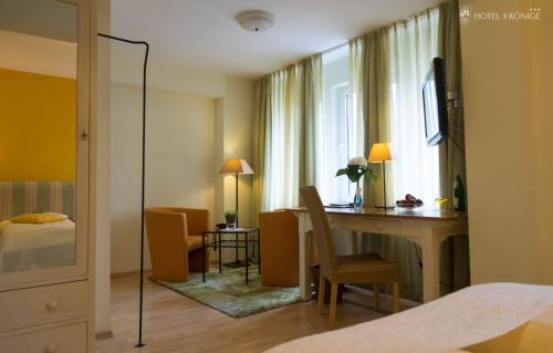a hotel room with a desk and a bed and a window at Hotel 3 Könige in Aachen