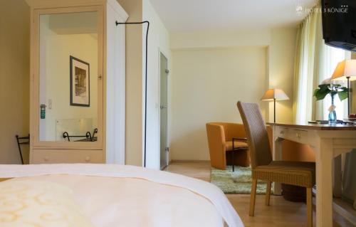 a bedroom with a bed and a desk and a table at Hotel 3 Könige in Aachen
