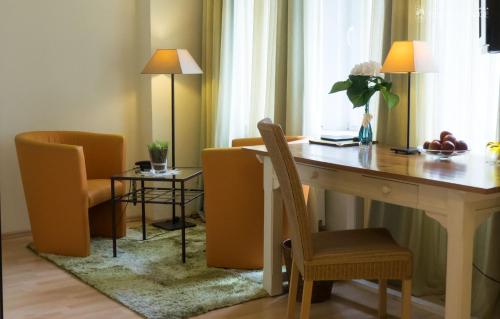 a room with a desk and chairs and a table and a window at Hotel 3 Könige in Aachen