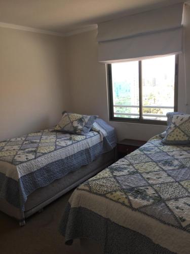 1 dormitorio con 2 camas y ventana en Mar Egeo, en Iquique