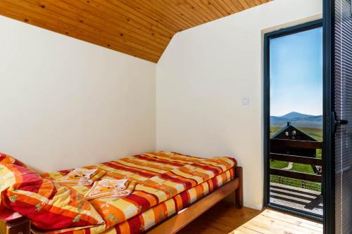 una camera da letto con un letto e una grande finestra di Guesthouse Wolf a Žabljak