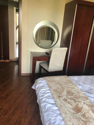 a bedroom with a bed and a desk with a mirror at Ana's Apartment in Chakvi Oasis in Chakvi