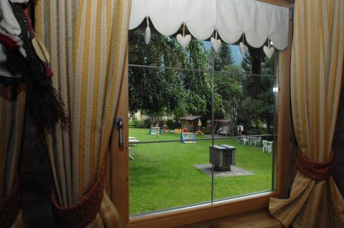 a window with a view of a yard with a park at Residence Lastè in Moena