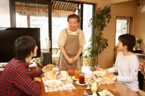 a man standing in front of a table eating food at Sapporo Inn Nada in Sapporo