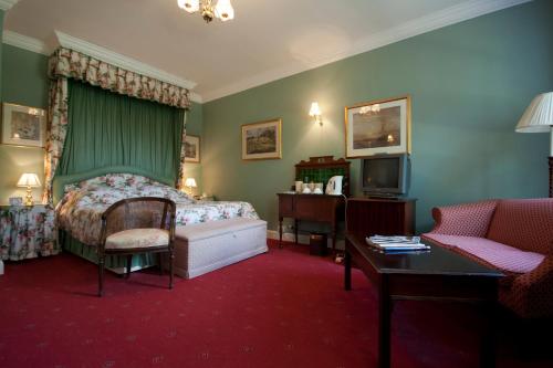 Corse的住宿－科西嘉草坪別墅酒店，一间卧室配有一张床、一张沙发和一张桌子